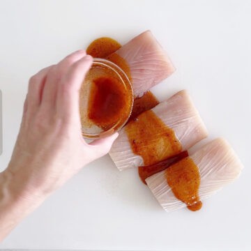 Coating mahi mahi with marinade.