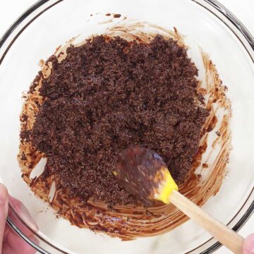 Mixing shredded coconut into melted chocolate.