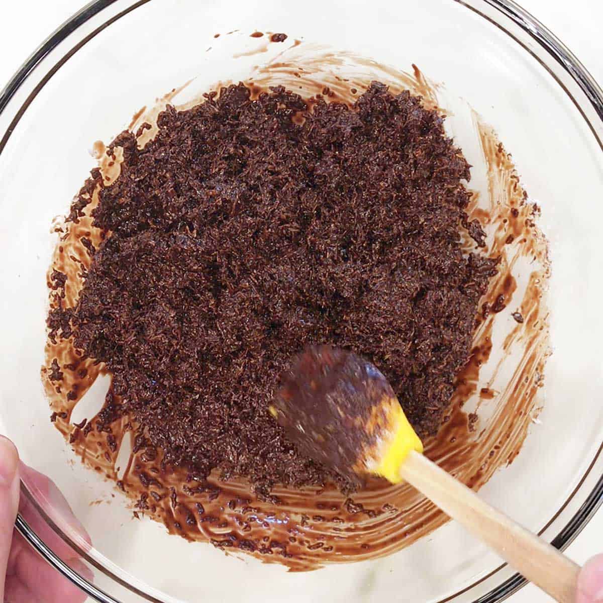 Mixing shredded coconut into melted chocolate.