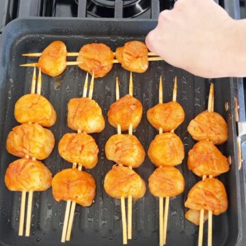 Placing the scallops on the grill.