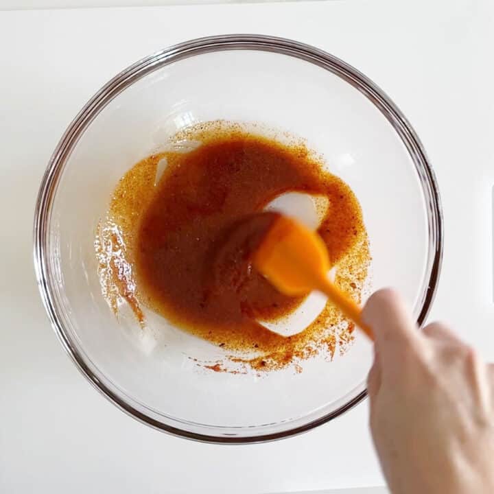 Mixing olive oil and spices in a bowl.