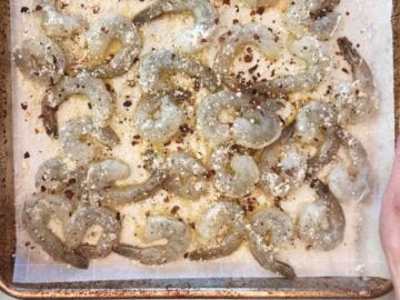 Seasoned shrimp on a baking sheet.