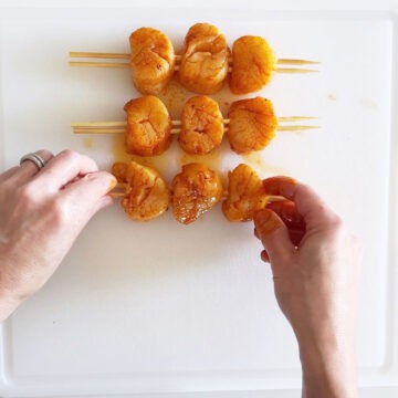 Threading the scallops onto skewers.