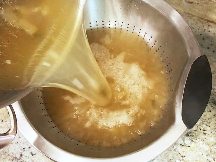 Straining the broth into a colander.