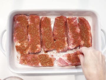 Seasoning the ribs with spices.