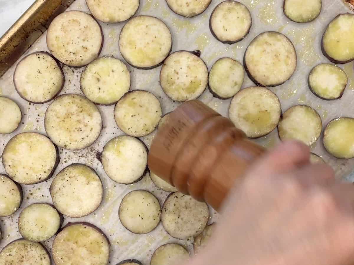 Seasoning the eggplant with black pepper.