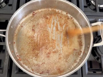Deglazing the skillet with a wooden spoon.