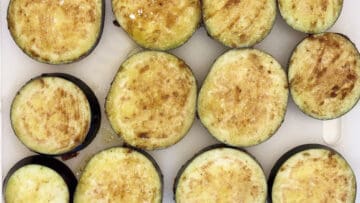 The eggplant slices are coated in the marinade.
