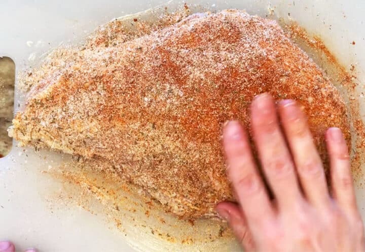 Rubbing turkey breast with spices.