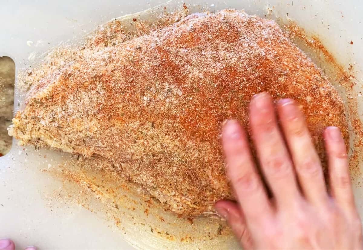 Rubbing turkey breast with spices.