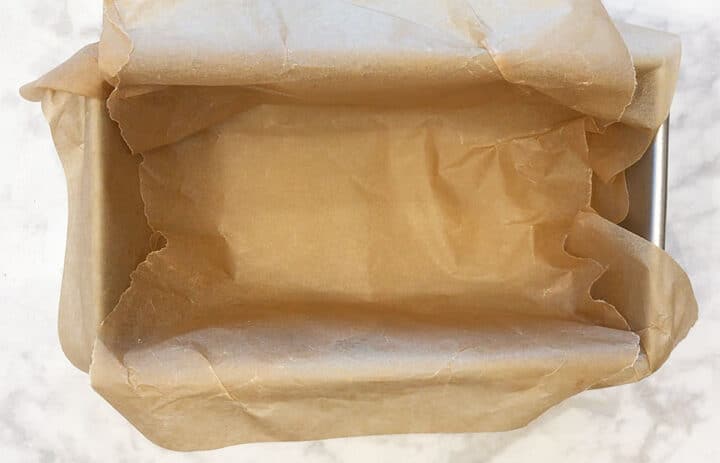 Loaf pan lined with parchment paper.