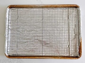 A rack fitted inside a rimmed baking sheet.