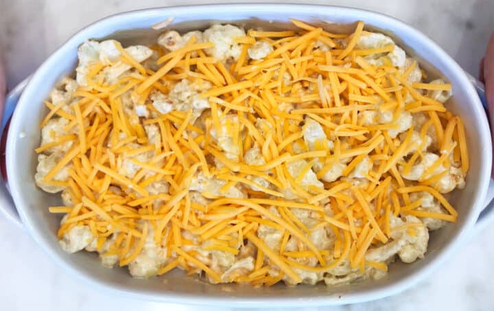 Cauliflower casserole in a baking dish, topped with cheese.