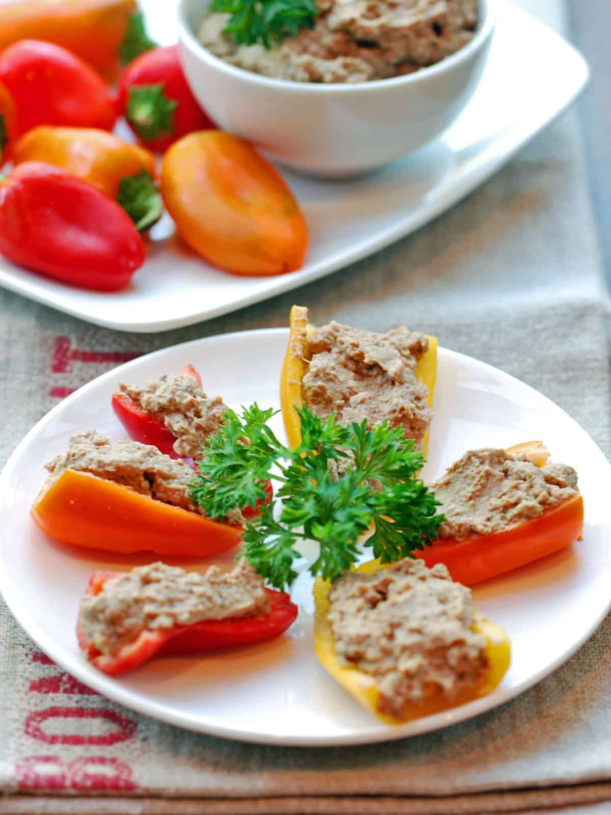 Chopped liver is served with mini peppers.