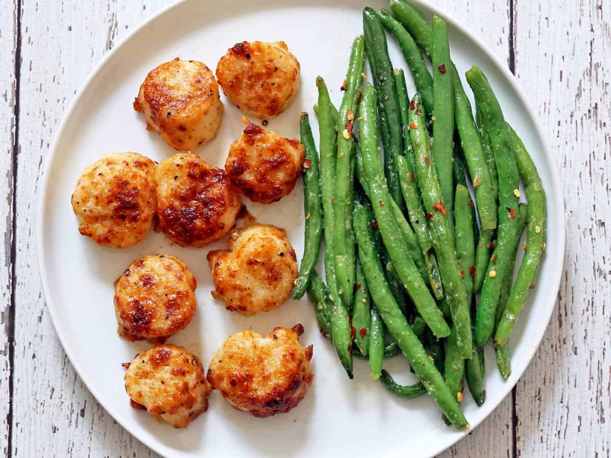 Sauteed green beans served with broiled scallops.