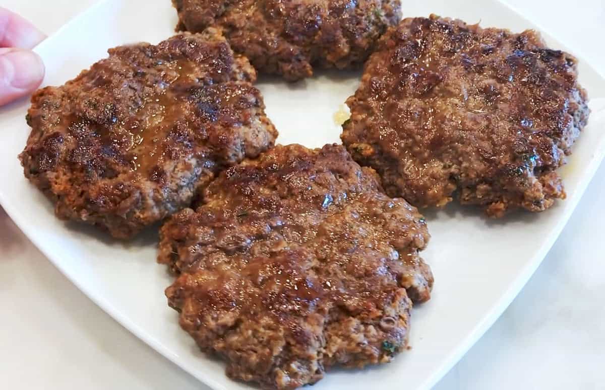The burgers are served on a white plate.