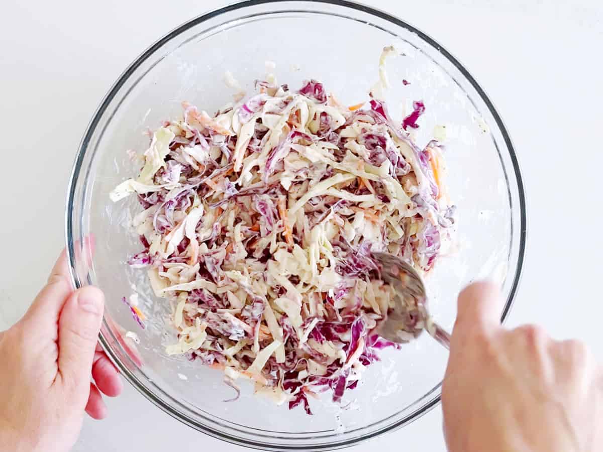 Mixing the cabbage and dressing.
