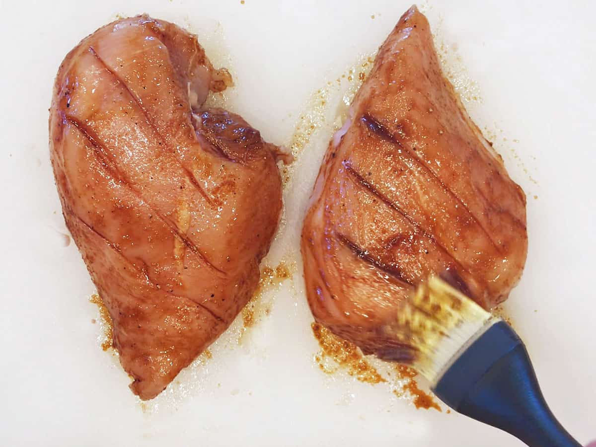 Brushing the chicken with the marinade.