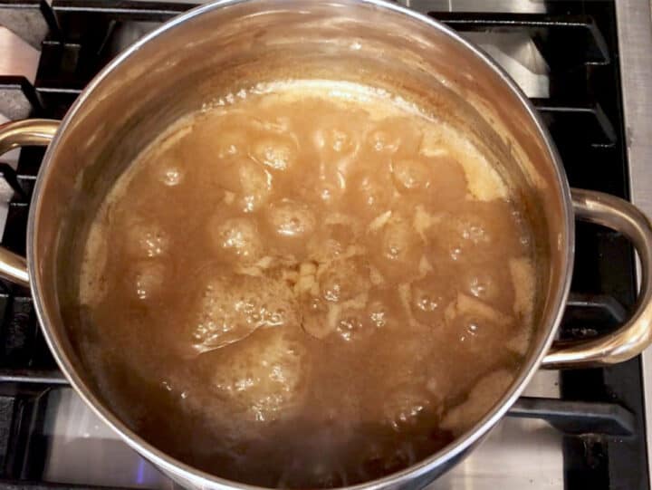 Reducing the cooking liquids on the stove.
