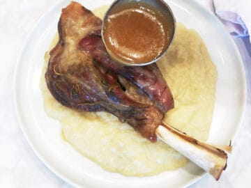 Serving a lamb shank over cauliflower rice and pouring the gravy on top.