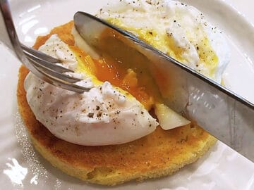 Cutting the poached egg open.