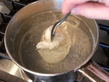 Pushing the egg white closer to the yolk.