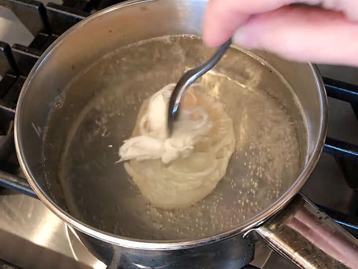 Pushing the egg white closer to the yolk.