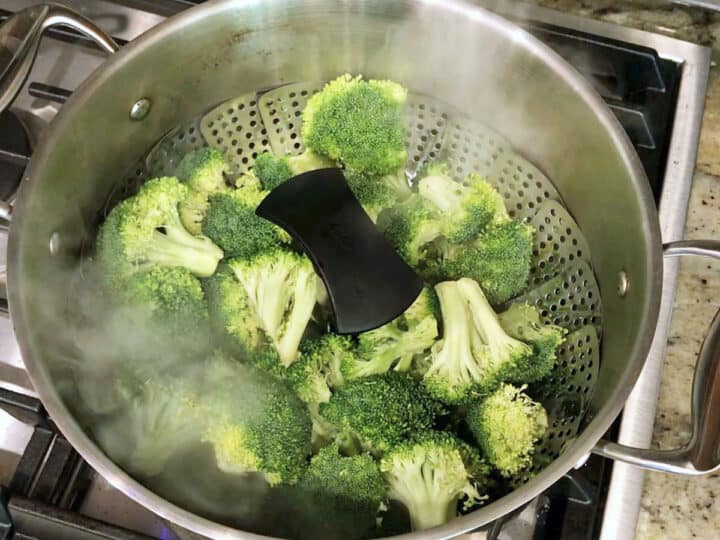Placing the steamer basket inside a stockpot with boiling water.