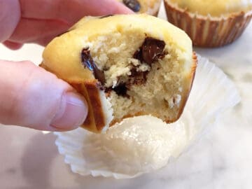 A hand holding a bitten muffin.