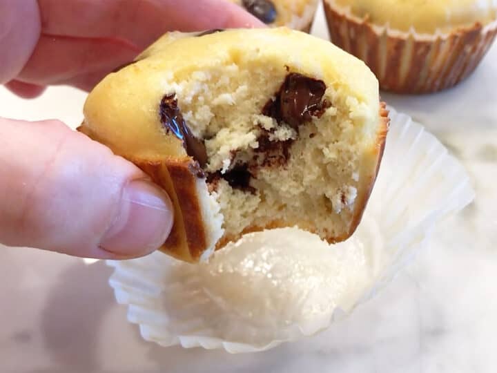 A hand holding a bitten muffin.