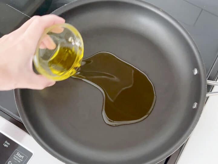 Adding olive oil to skillet.