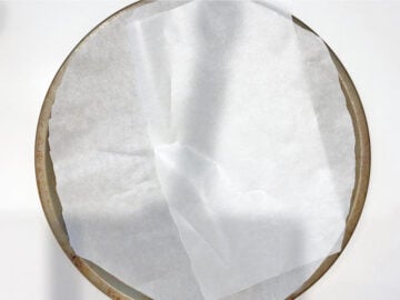 Pizza pan lined with parchment paper.