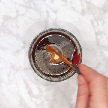 Adding BBQ sauce ingredients in a jar.