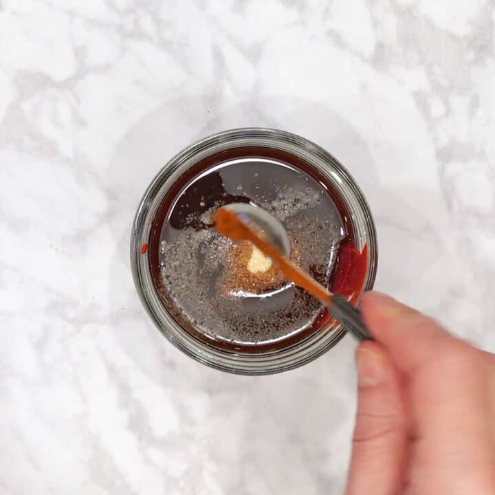 Adding BBQ sauce ingredients in a jar.