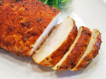 Sliced Cajun chicken on a cutting board.