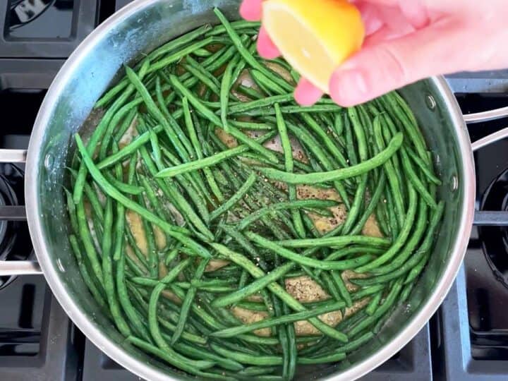 Seasoning haricot verts with lemon juice.