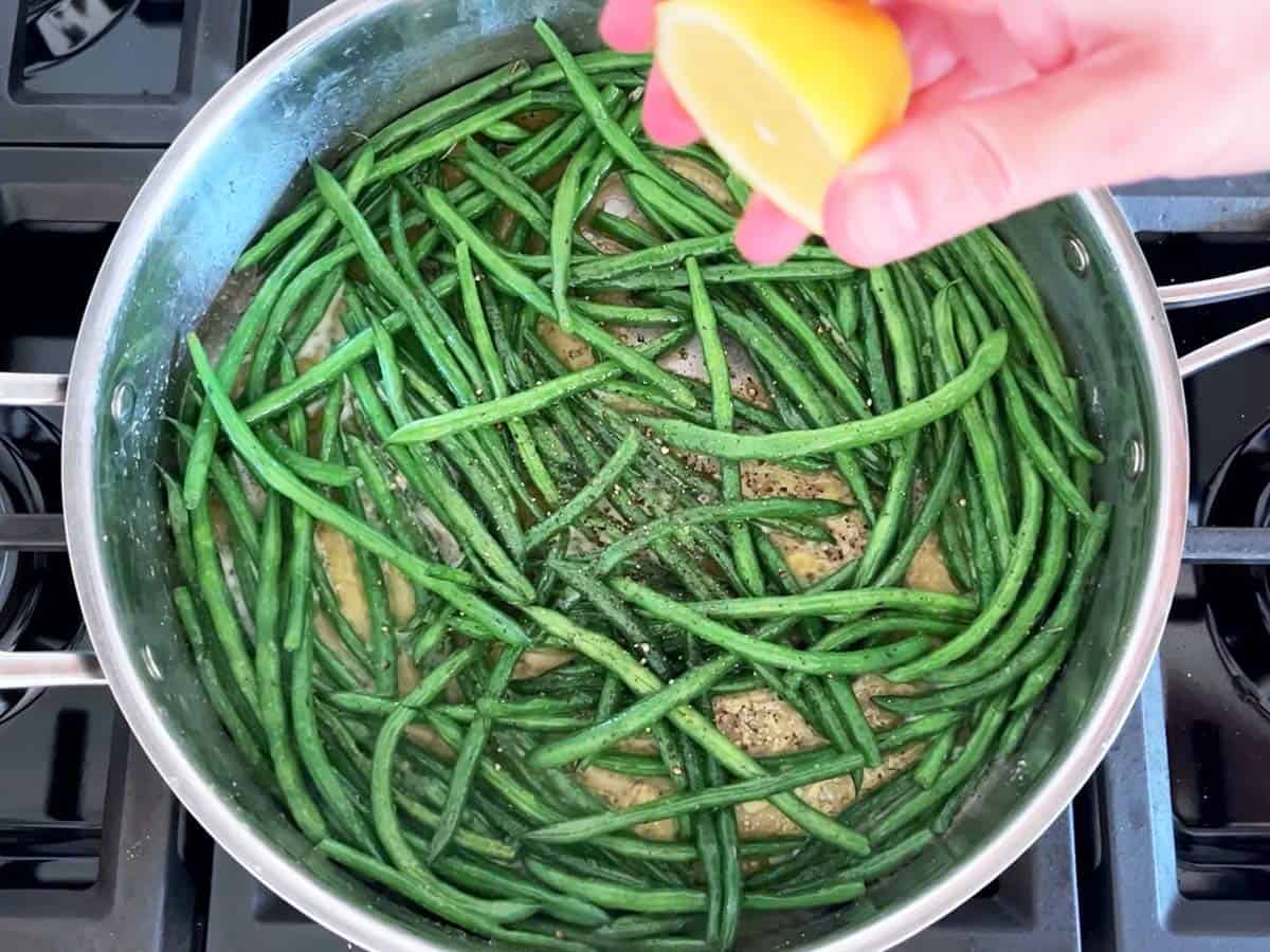 Seasoning haricot verts with lemon juice.