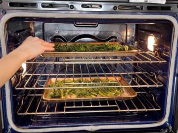 Placing the broccolini in the oven.