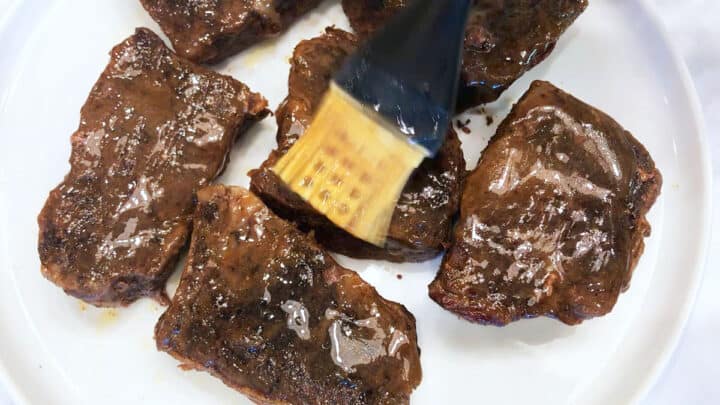 Brushing the ribs with the cooking liquids.