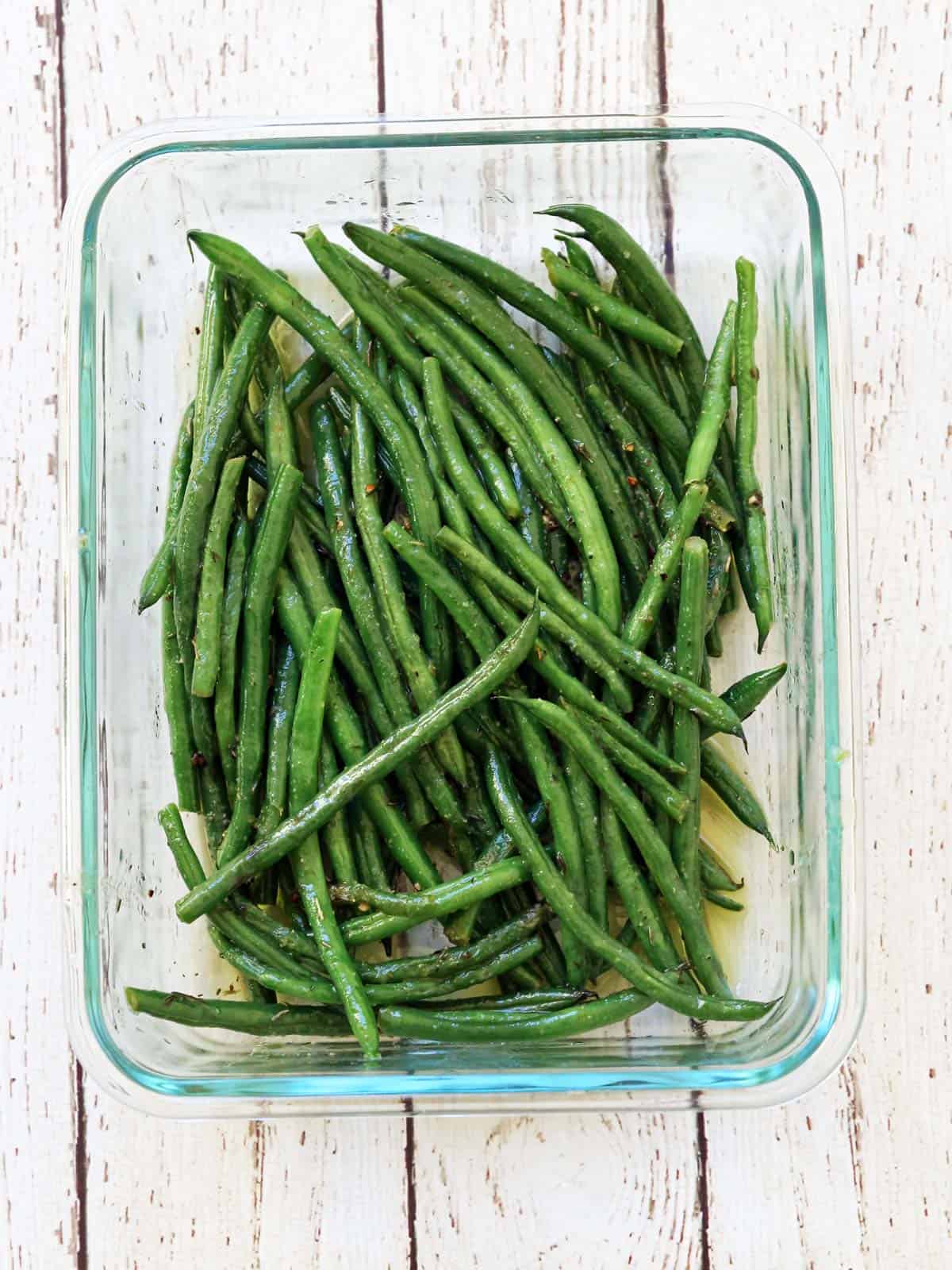 Storing haricot verts leftovers in a glass food storage container.