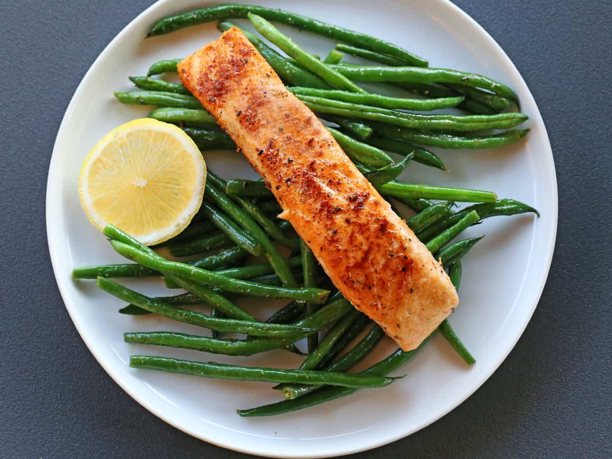 Haricot verts are served with salmon.