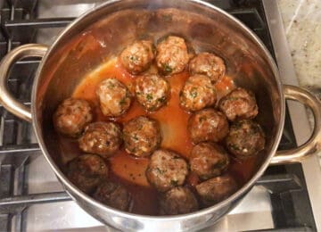 Coating the meatballs in the glaze.