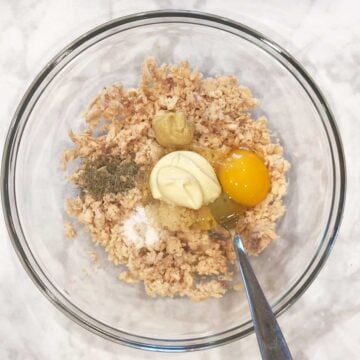 Adding more ingredients to the bowl.