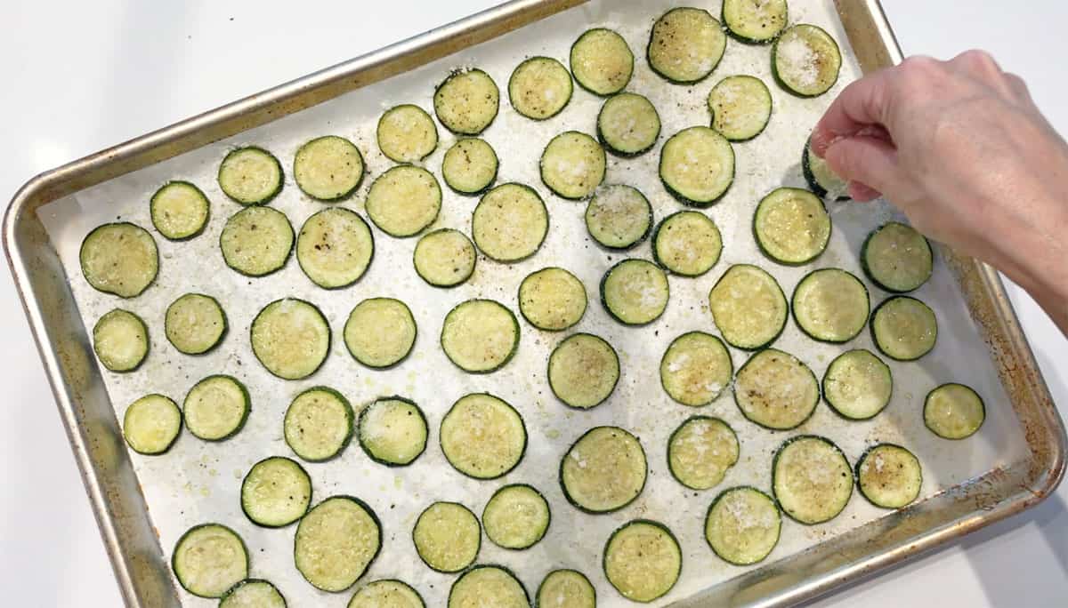 Seasoning the zucchini chips.