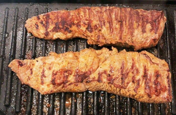 Grilling the steak on the second side.