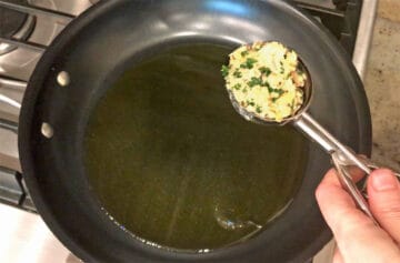 Measuring the salmon cakes with an ice cream scoop.