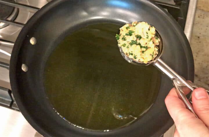Measuring the salmon cakes with an ice cream scoop.