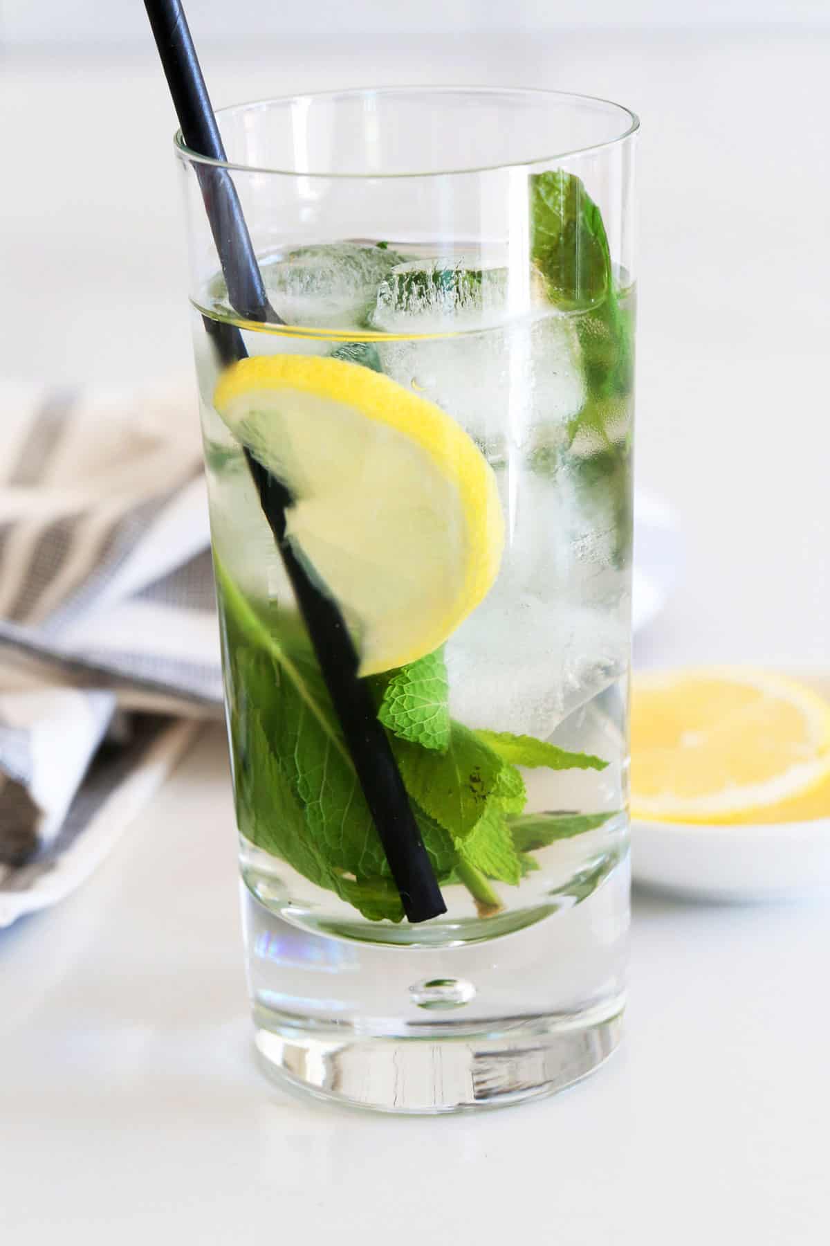 Iced mint tea is served in a tall glass.