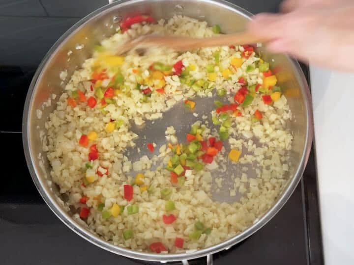 Adding peppers to the skillet.