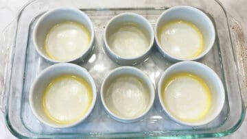 Buttered ramekins in a water bath.